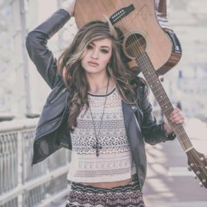 Kenzi Lewis holding a guitar featured in American Idol